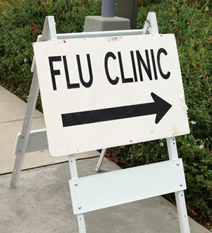 a white directional sign for a flu clinic.